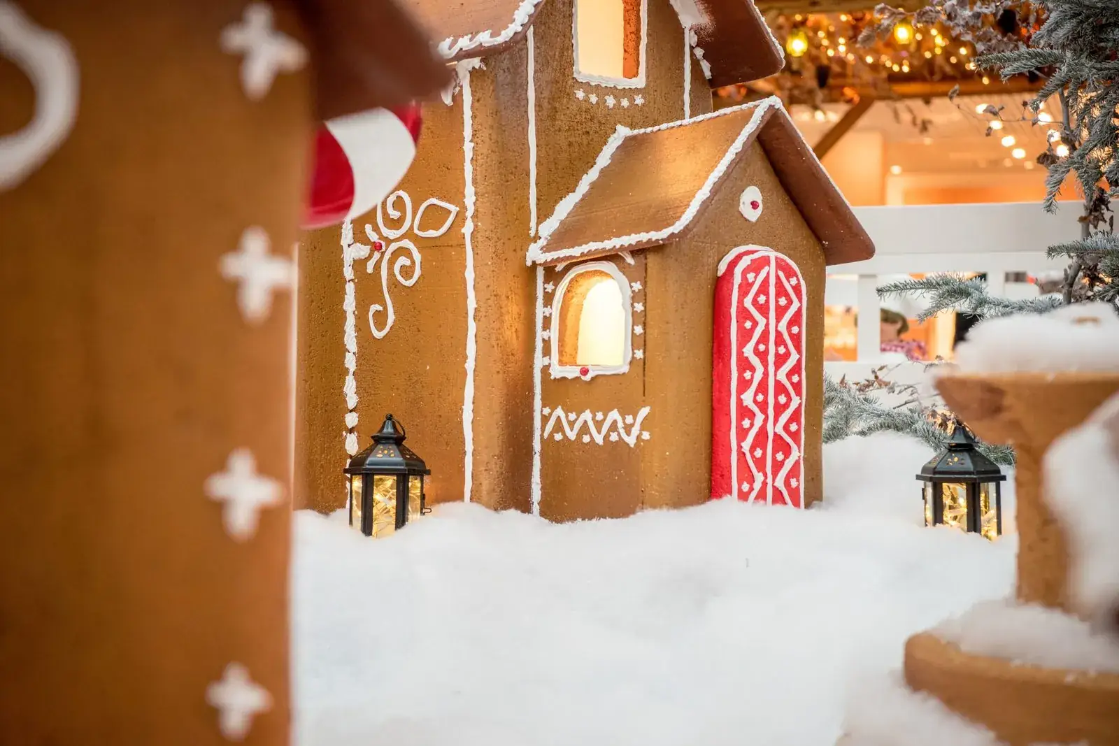 Maison illuminée et lanternes allumées dans un décor de neige